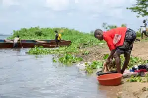 A young woman called Prossy washes her blanket in the river at Kabaganda Landing site, Kamuli district of Uganda, putting her at risk of schistosomiasis infection.