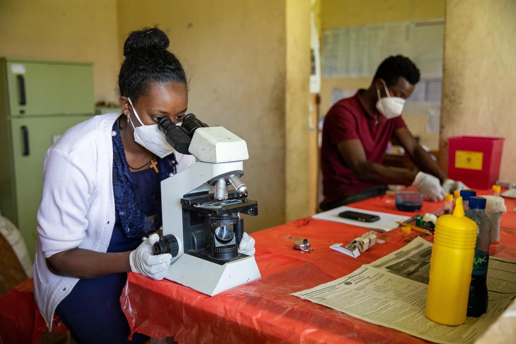 Lab Technician Etalem Shibiru (left) examines stool samples while her partner Dawit Samuel prepares slides using stool samples collected during the Parameter Validation Survey in Kuka Kebele, Shey Bench Woreda, Bench Maji Zone, SNNPR.