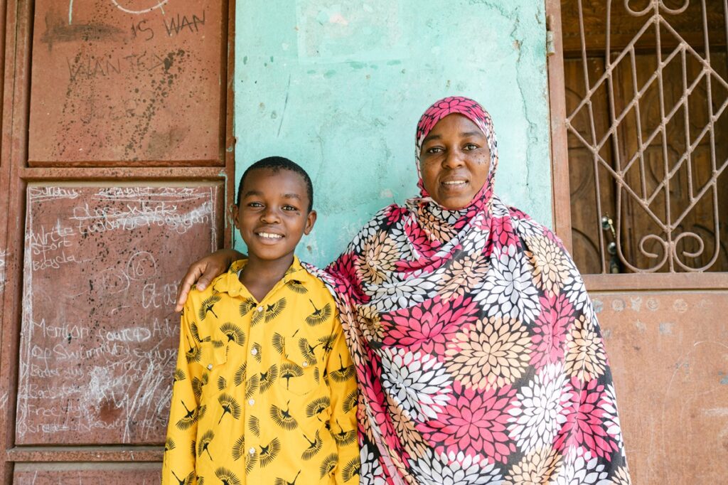 Abdul 12, and his mother Zamrat, standing outside their home in Mto Barafu, Stone Town. After receiving treatment he recovered from schistosomiasis, a waterborne parasitic disease endemic to the country.